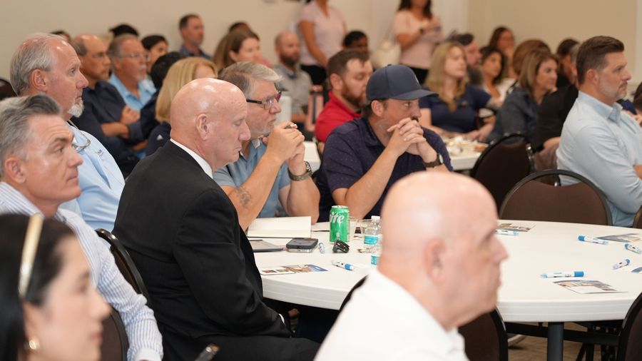 Attendees applaud while seated at round tables during the GOBA event.