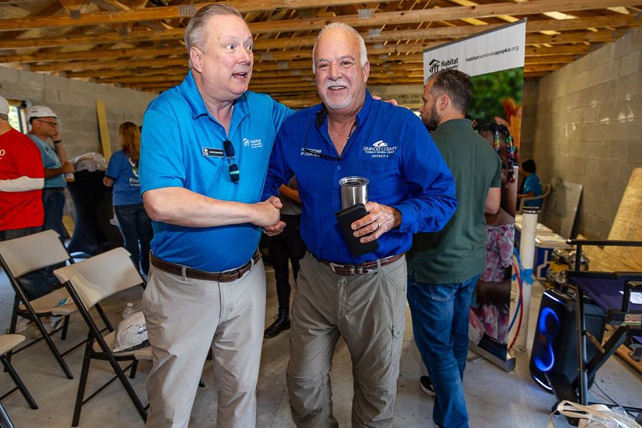 Two attendees posing together inside the Executive Build site.