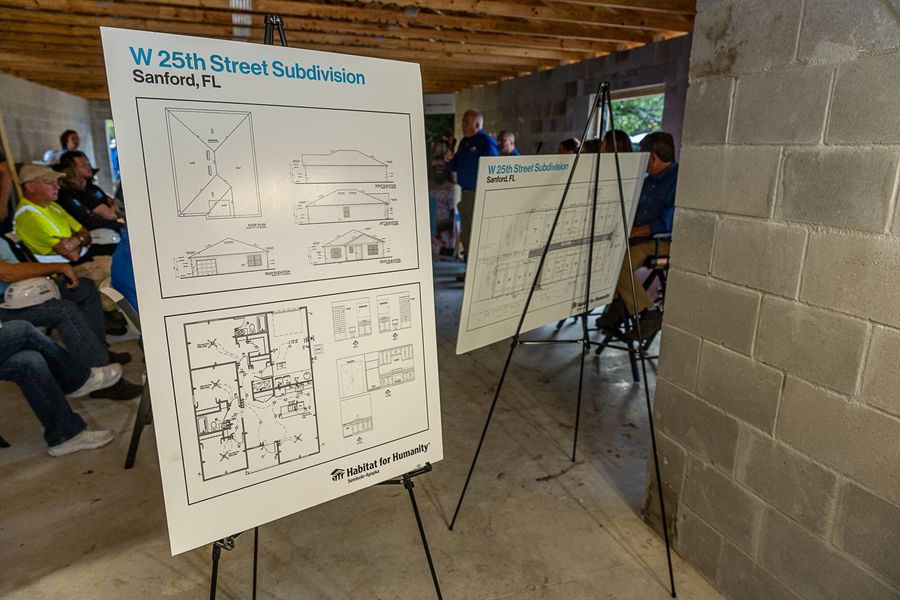 Architectural drawings displayed on easels inside the build site.