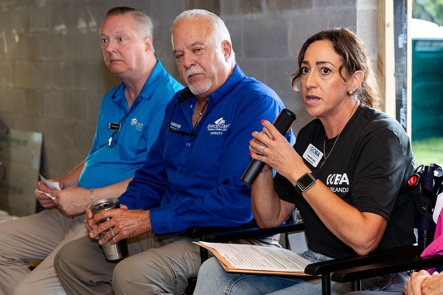 A participant speaking into a microphone during the Executive Build discussion.