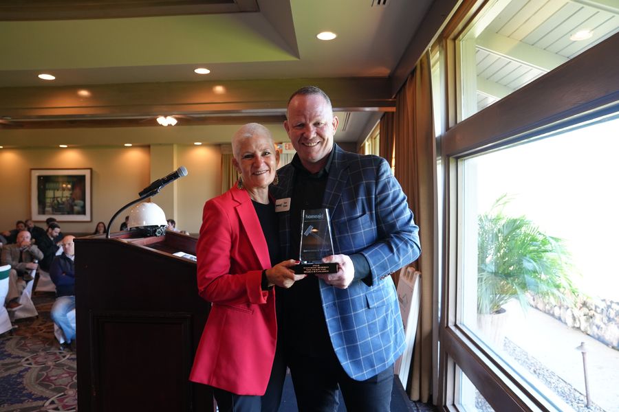 Two guests holding an award near the lectern.