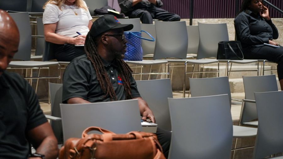An attendee follows the workshop with a laptop open on his lap.