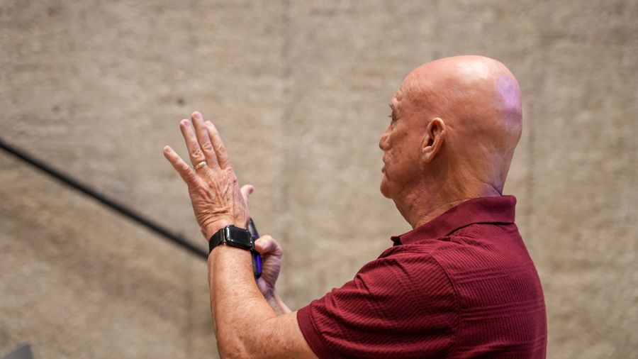 Side view of the presenter illustrating a point with his hands.
