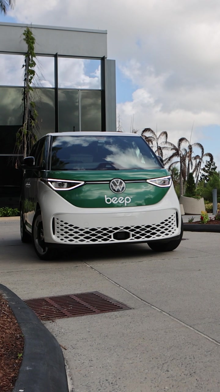 A Beep vehicle parked outside a glass-fronted building